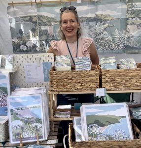Artist Beth Hill stood behind her craft stall with prints of Torbay